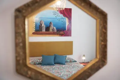 a mirror reflecting a bed with two blue pillows at Le Tare B&B in Rome