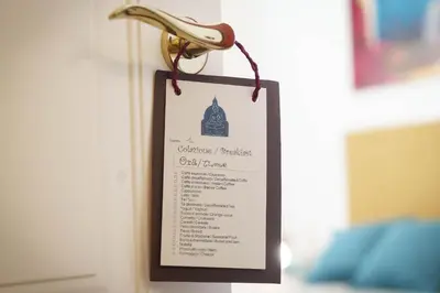 a sign hanging on a wall with a menu at Le Tare B&B in Rome