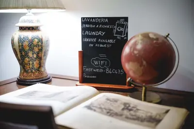 a table with a book and a lamp and a globe at Le Tare B&B in Rome