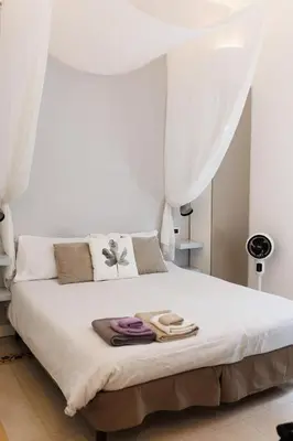 a bedroom with a white bed with white curtains at Casa Caudì in Rome