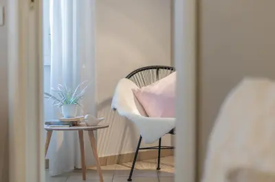 a chair with a pink pillow sitting next to a table at Vaticano San Pietro Apartment in Rome