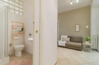 a bathroom with a toilet a sink and a couch at Vaticano San Pietro Apartment in Rome