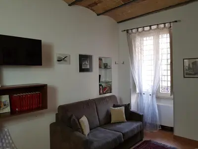 a living room with a couch and a window at Elegante appartamento immerso nei Fori Imperiali in Rome