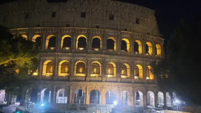 a night view of the leaning tower of colossus at Elegante appartamento immerso nei Fori Imperiali in Rome