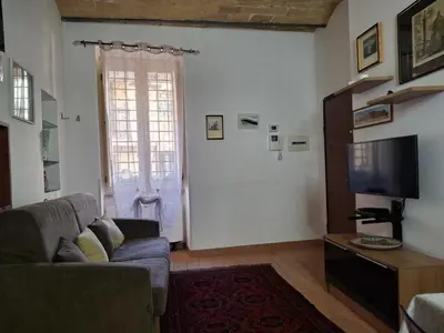 a living room with a couch and a tv and a door at Elegante appartamento immerso nei Fori Imperiali in Rome