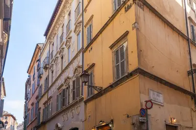 a yellow building with windows on a street at Domus Lupae -live in the heart of Rome in Rome