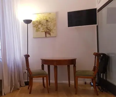 a room with a table and two chairs and a television at Domus Lupae -live in the heart of Rome in Rome