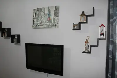 a flat screen tv hanging on a wall with pictures at condottieri al pigneto in Rome