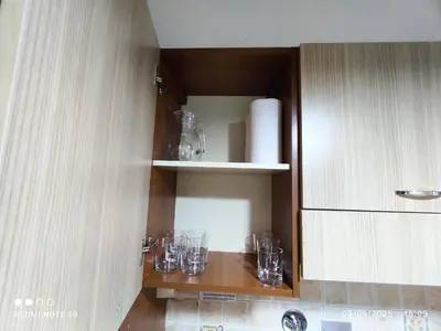 a kitchen with glasses on a shelf in a cabinet at condottieri al pigneto in Rome