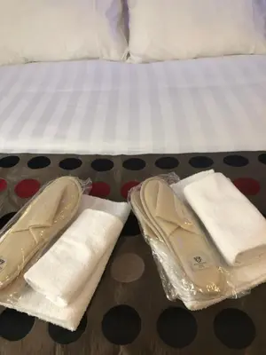 a pair of shoes and towels on a bed at Room 76 in Rome