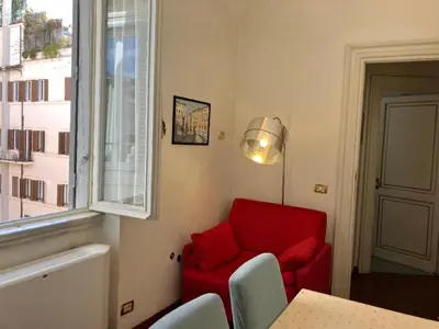 a living room with a red chair and a window at Apartment Spanish Steps with panoramic roof-terrace in Rome