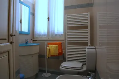 a bathroom with a toilet and a sink and a window at Apartment Spanish Steps with panoramic roof-terrace in Rome