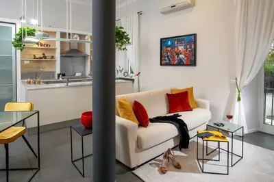 a living room with a white couch with red and yellow pillows at SECRET GARDEN - Amazing Loft in The Imperial Rome in Rome