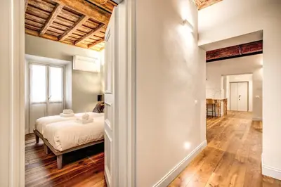 a bedroom with a bed and a hallway with a desk at Febo Decharm apartment in Rome