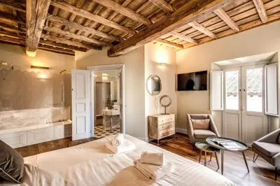 a bedroom with a large bed and a bathroom at Febo Decharm apartment in Rome