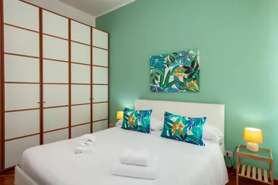 a bedroom with a white bed with blue walls at Tizy & Toto's apartment near Vatican in Rome