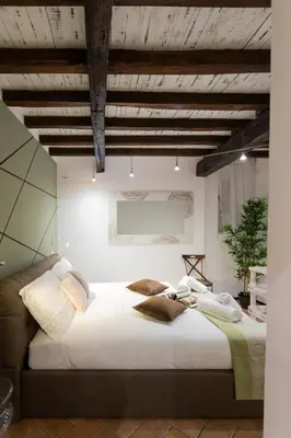 a bedroom with a large bed with white sheets and pillows at Sofia alla VII Coorte in Rome