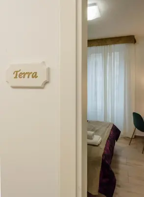 a bedroom with a bed and a sign on a door at Le vestali Guest House in Rome