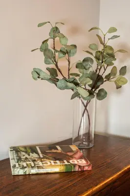 a vase with a plant and a magazine on a table at 8 HOME in Rome