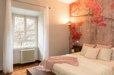 a bedroom with a bed with a painting on the wall at 8 HOME in Rome