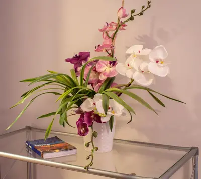 a vase filled with flowers on a glass table at 8 HOME in Rome