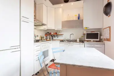 a kitchen with white cabinets and a white counter top at Appartamento via del Teatro Pace in Rome