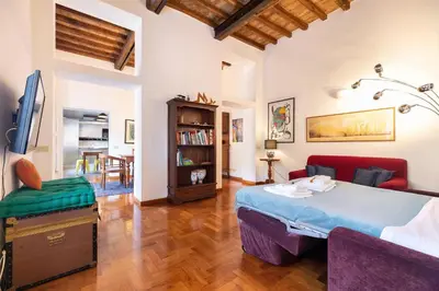 a bedroom with a bed and a living room at Appartamento via del Teatro Pace in Rome