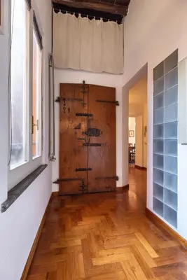 a large wooden door in a room with a wooden floor at Appartamento via del Teatro Pace in Rome