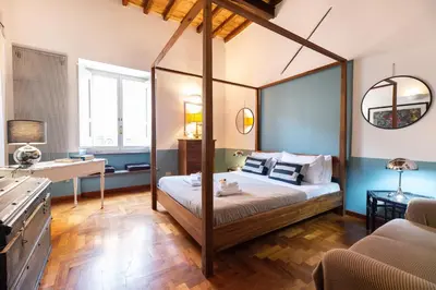 a bedroom with a canopy bed and a desk at Appartamento via del Teatro Pace in Rome