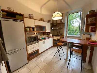 a kitchen with a table and a white refrigerator at OB1 Vacanze Romane in Rome