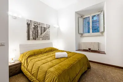 a bedroom with a yellow bed and a window at Tour de Rome in Rome