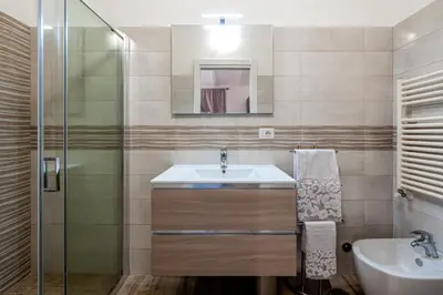 a bathroom with a sink and a glass shower at Tour de Rome in Rome