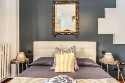a bedroom with a bed with a mirror on the wall at Stasera a casa da M.E. in Rome