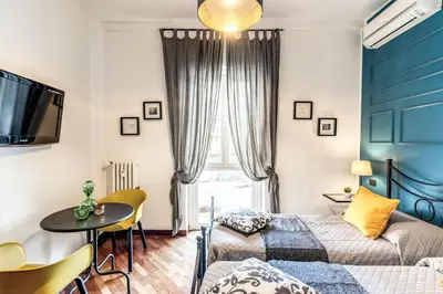 a living room with a bed and a table and a tv at Stasera a casa da M.E. in Rome