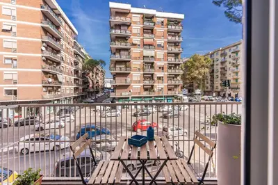 a balcony with a table and chairs on a city street at Stasera a casa da M.E. in Rome