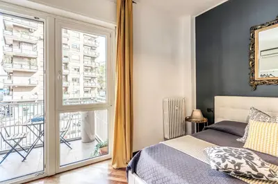 a bedroom with a bed and a large window at Stasera a casa da M.E. in Rome