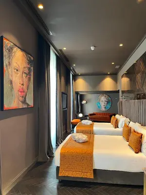 a bedroom with two beds and a painting on the wall at U-Visionary Roma Hotel in Rome