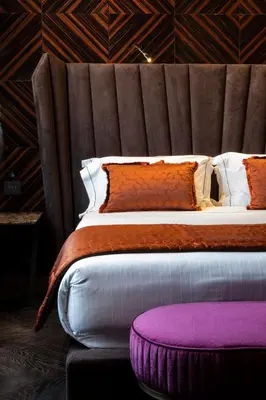 a bedroom with a large bed with a large headboard at U-Visionary Roma Hotel in Rome
