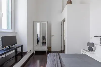 a white bedroom with a bed and a tv at iFlat Colosseum Comfy House in Rome
