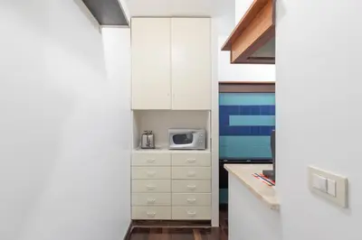 a kitchen with white cabinets and a microwave at iFlat Colosseum Comfy House in Rome