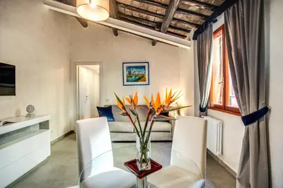a dining room with a glass table and white chairs at Tritone Top House in Rome