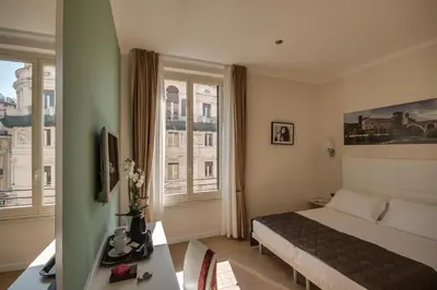 a hotel room with a bed and two windows at Tritone Top House in Rome