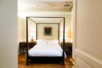 a large bed with a blue headboard and two night stands at Incentrum in Rome