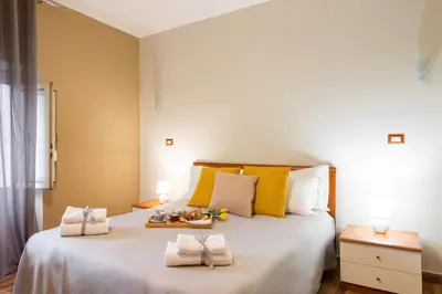 a bedroom with a large white bed with yellow pillows at Rome's Best Holidays Guest House in Rome