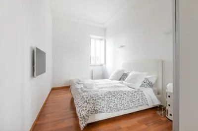 a white bedroom with a bed and a mirror at Stay In Rome in Rome
