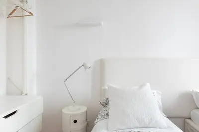 a white bedroom with a bed and a lamp at Stay In Rome in Rome