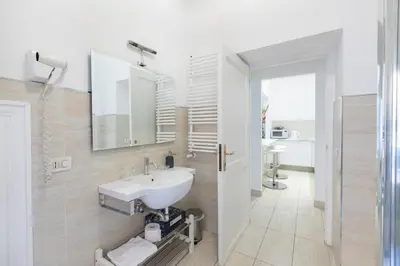 a white bathroom with a sink and a mirror at Stay In Rome in Rome
