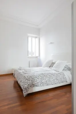 a white bedroom with a bed in a room at Stay In Rome in Rome