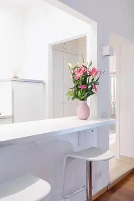 a white room with a vase of flowers on a counter at Stay In Rome in Rome