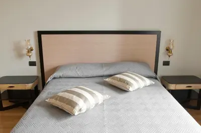 a bed with two pillows on it with two tables at Le Cupoline in Rome